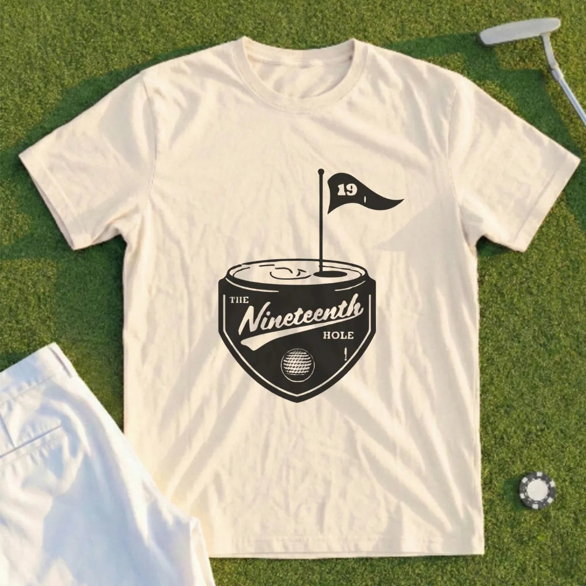 Cream t-shirt with "The Nineteenth Hole" logo featuring a golf flag on a can.