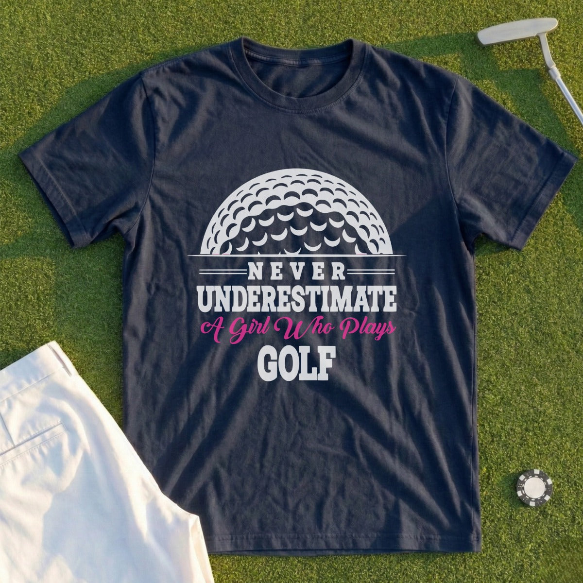 Navy t-shirt with text "Never Underestimate A Girl Who Plays Golf" and a golf ball graphic.