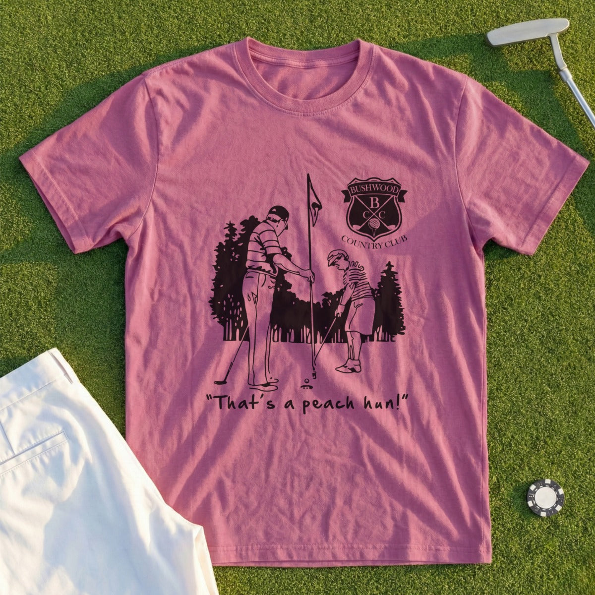 Pink t-shirt with "Bushwood Country Club" logo and a golfer saying "That's a peach hun!"