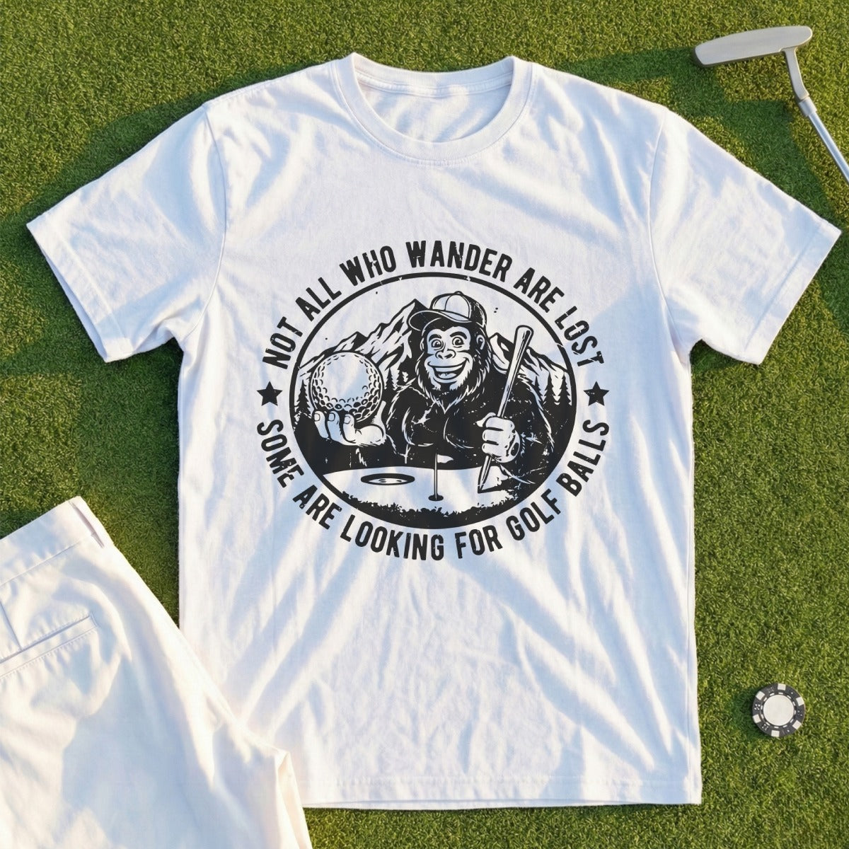 White t-shirt with monkey holding golf ball, text "Not all who wander are lost, some are looking for golf balls".