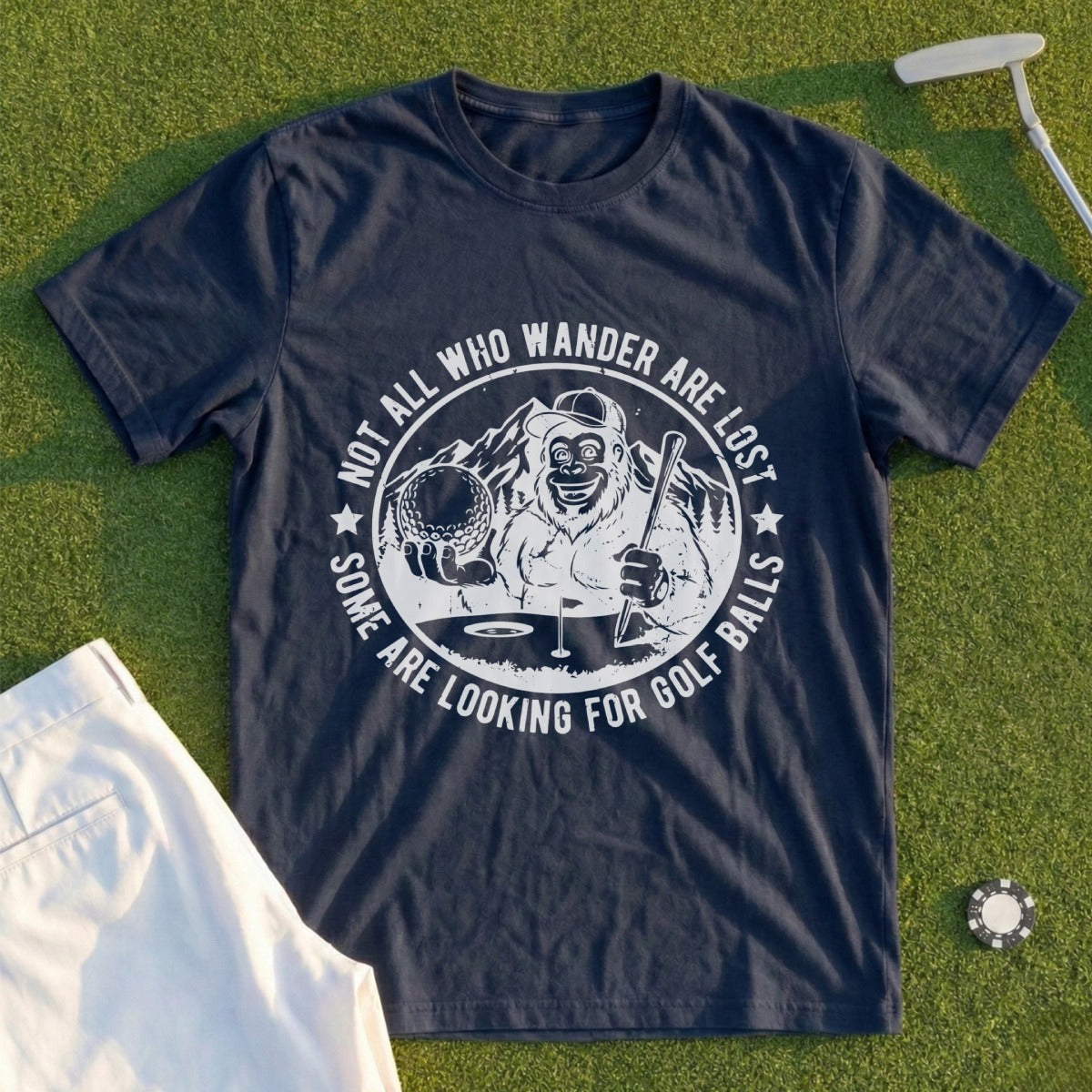 Dark blue t-shirt with a graphic of a Bigfoot holding a golf club and ball.
