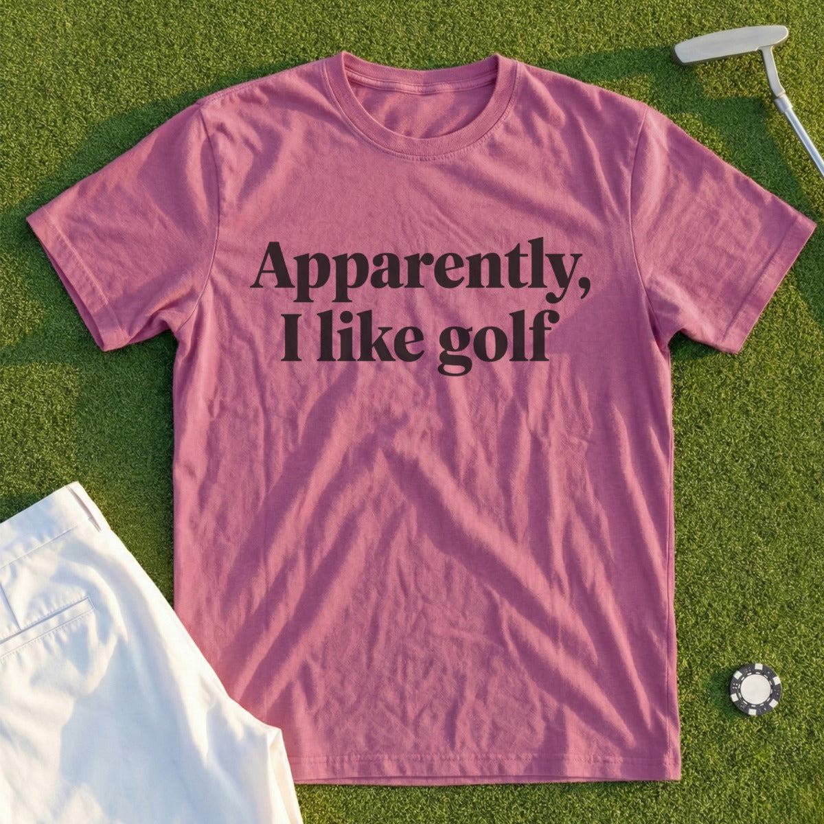 Pink t-shirt with "Apparently, I like golf" text, with golf items.