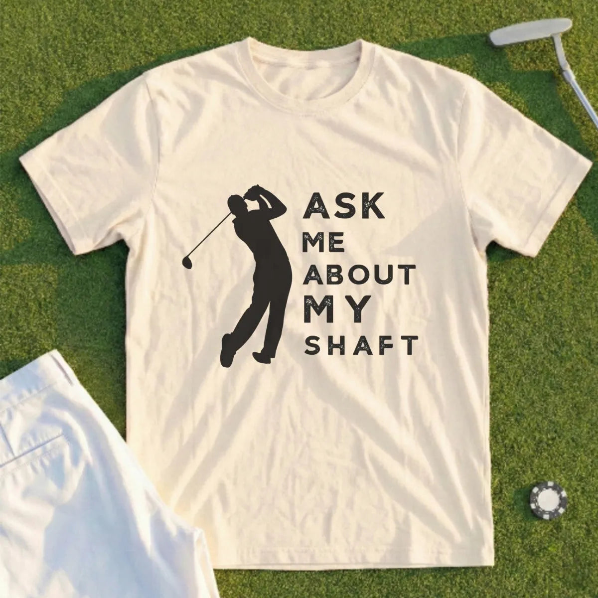 Cream t-shirt with black graphic of golfer and text "ASK ME ABOUT MY SHAFT".