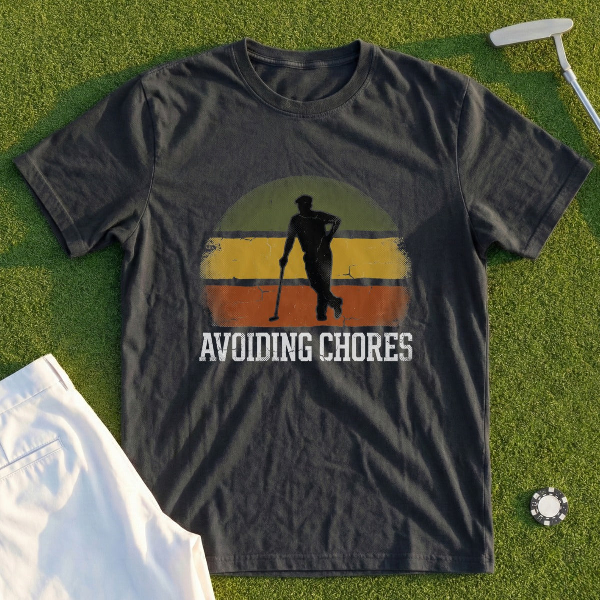 Dark t-shirt with a vintage sunset graphic and "AVOIDING CHORES" text.