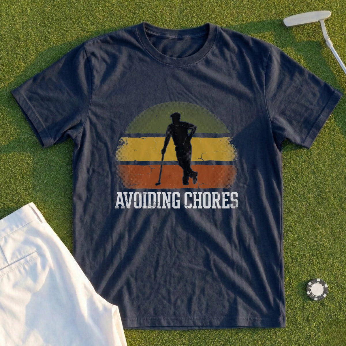 Navy t-shirt with "Avoiding Chores" and a golfer silhouette on a striped background.