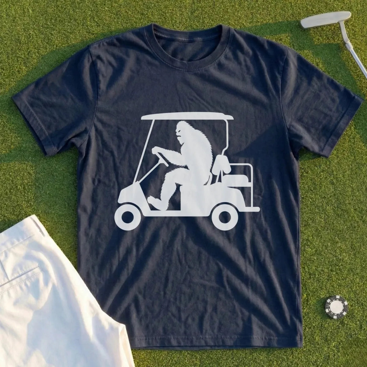Bigfoot driving a golf cart on a grass background.