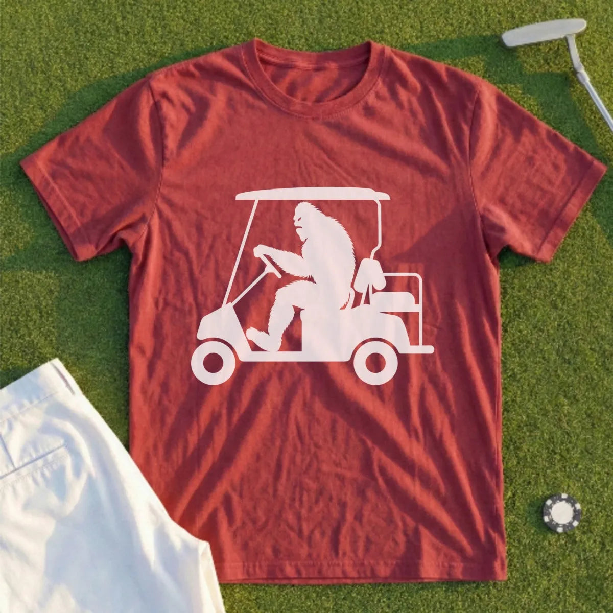 Bigfoot driving a golf cart on a green shirt.