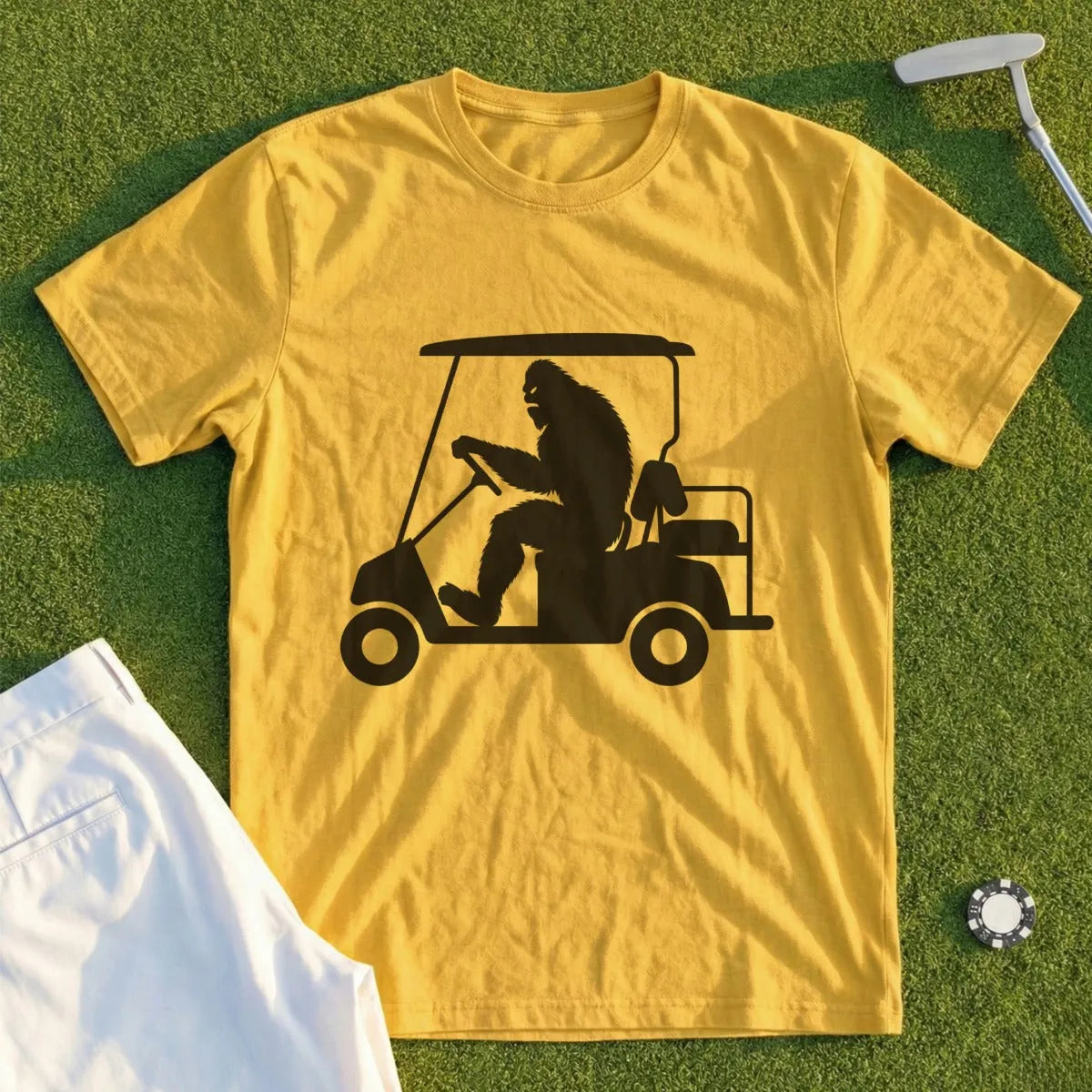 Yellow t-shirt with Bigfoot driving a golf cart graphic.