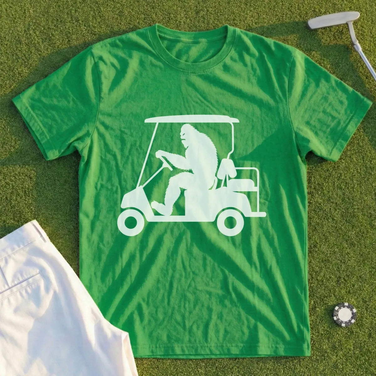Green t-shirt with white Bigfoot driving a golf cart graphic.