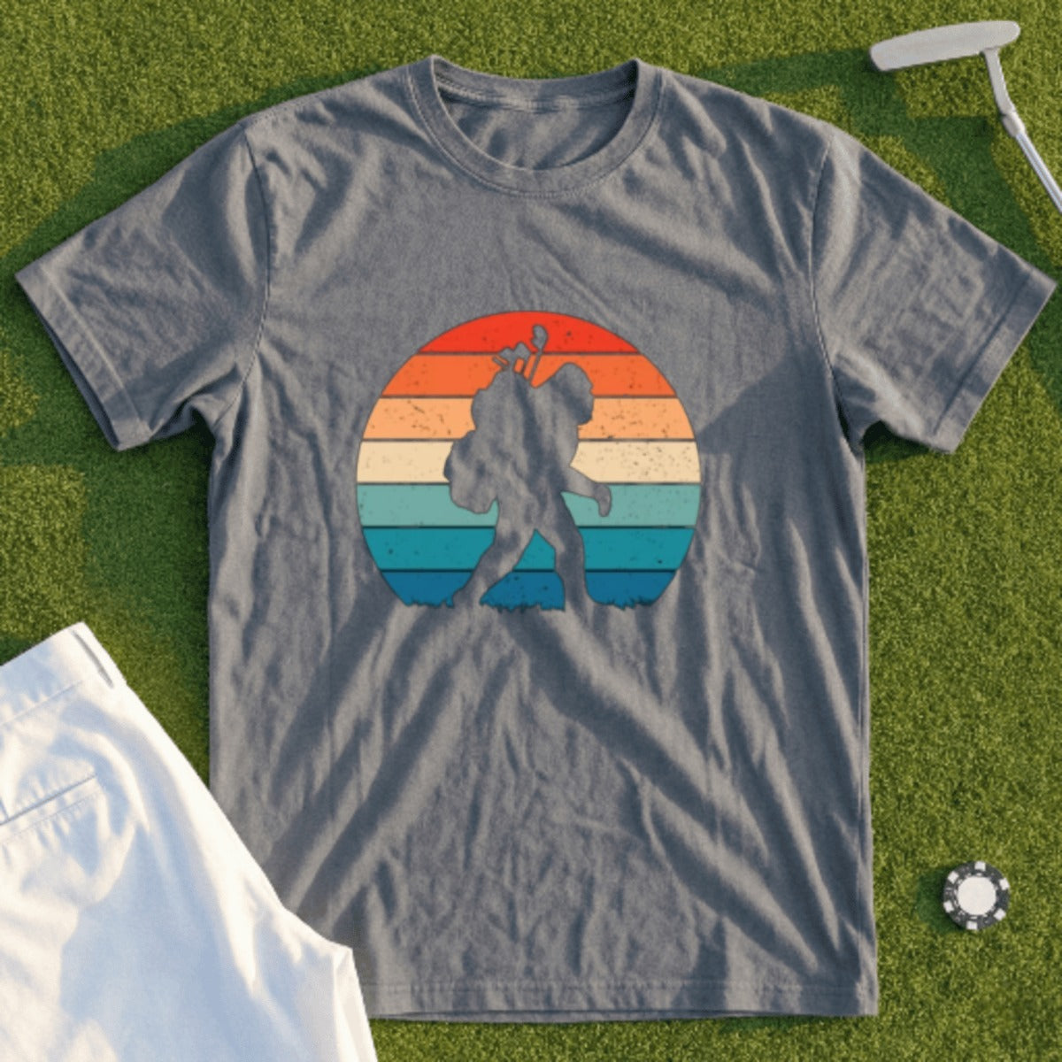 Bigfoot silhouette against a retro sunset on a gray graphic t-shirt.