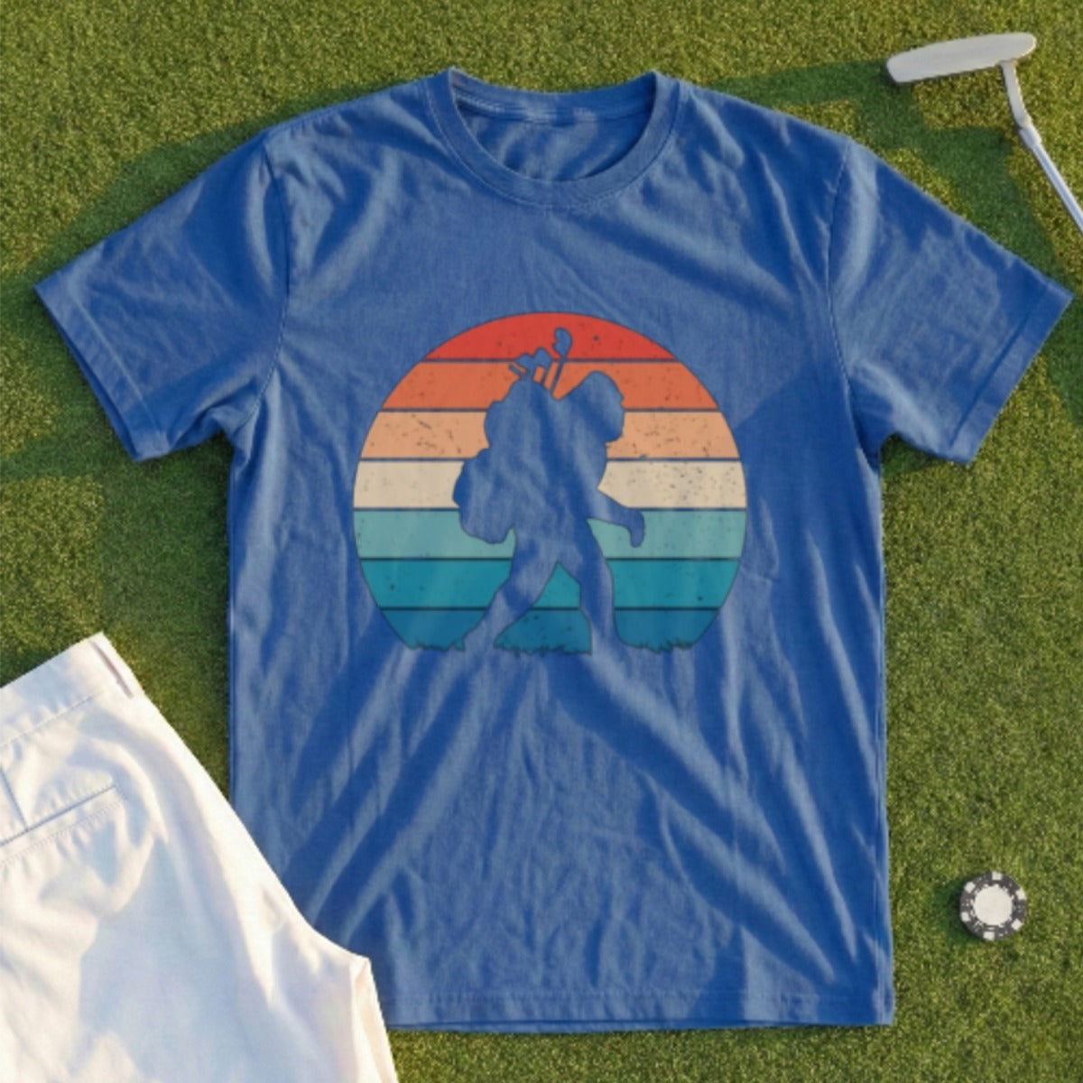 Blue t-shirt with a retro sunset graphic of Bigfoot carrying a backpack.