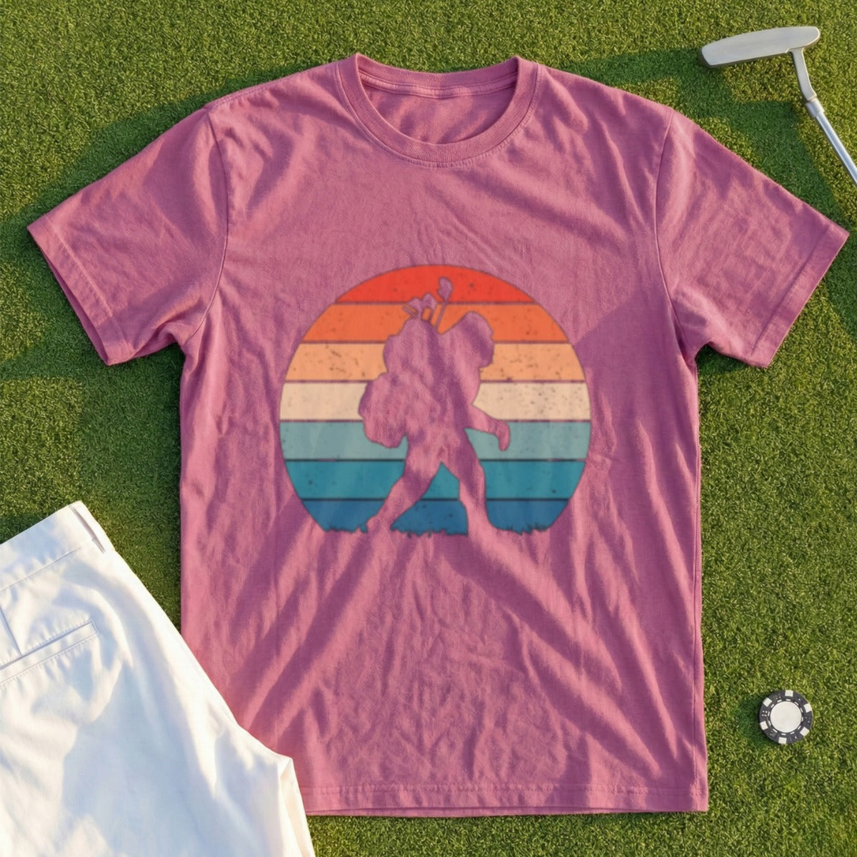 Bigfoot silhouette on a sunset graphic on a pink t-shirt.