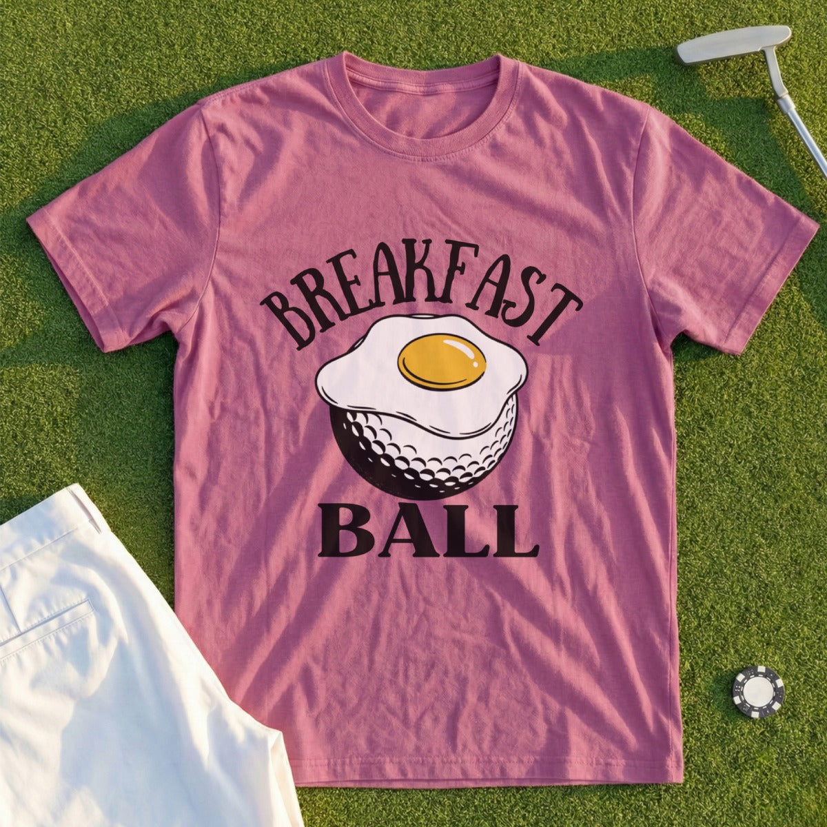 Pink t-shirt with "BREAKFAST BALL" text above a fried egg on a golf ball.