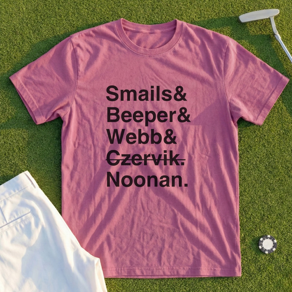 Rose t-shirt with "Smails & Webb & Czervik. Noonan." text, on grass.