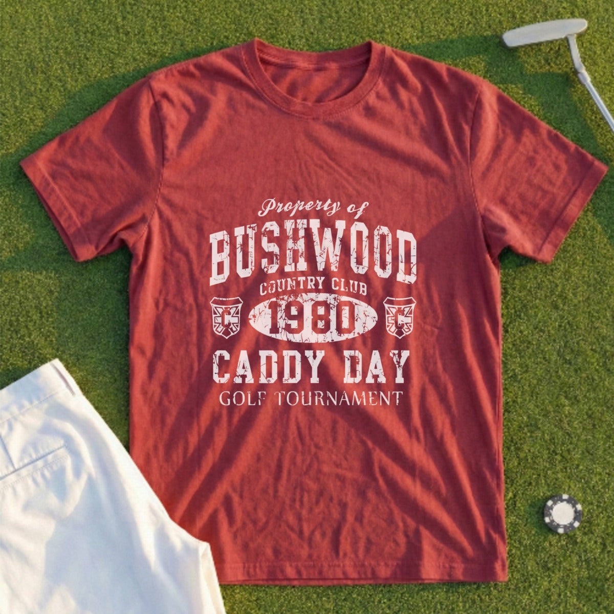 Red t-shirt with "Bushwood Country Club Caddy Day Golf Tournament" text.