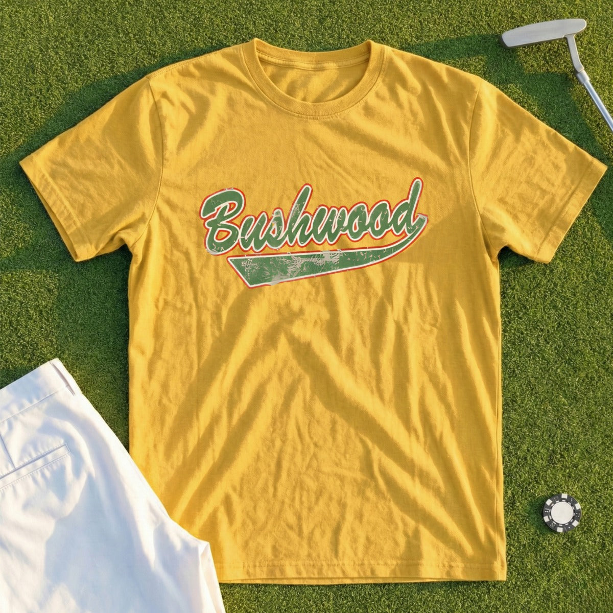 Yellow t-shirt with "Bushwood" text in red and green vintage script.