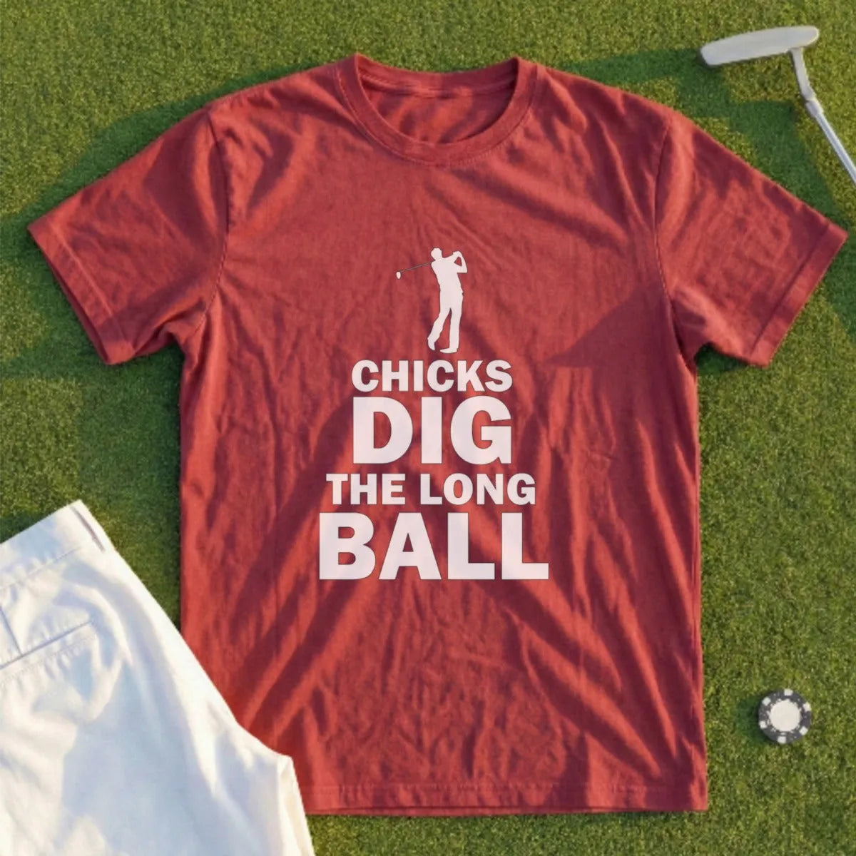Red t-shirt with "CHICKS DIG THE LONG BALL" text, on a golf course background.
