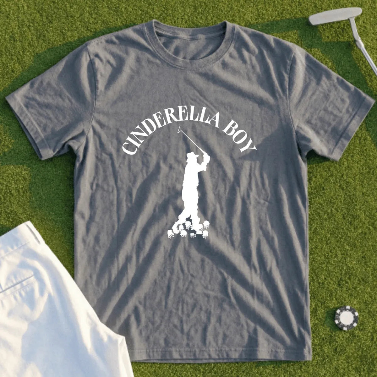 Gray t-shirt with white "Cinderella Boy" text and golfer graphic on grass.