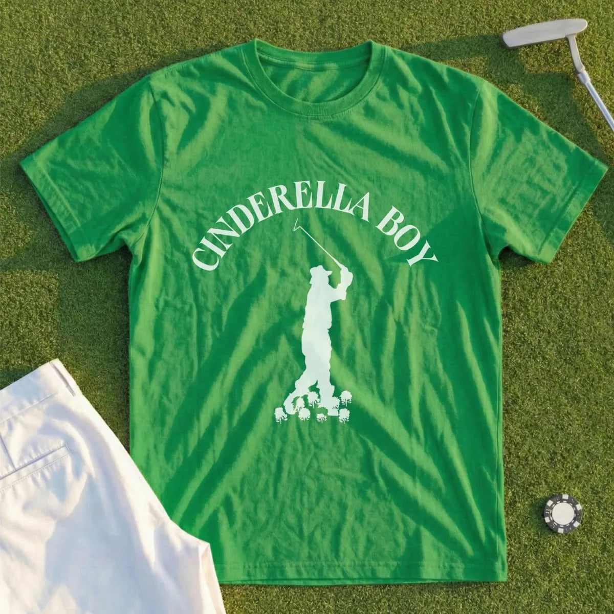 Green t-shirt with "CINDERELLA BOY" and golfer silhouette on grass.