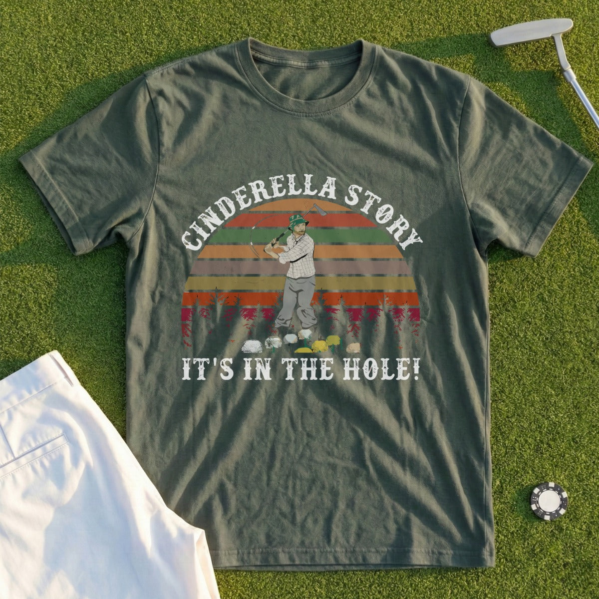 T-shirt with "Cinderella Story IT'S IN THE HOLE!" text and golfer on green grass.