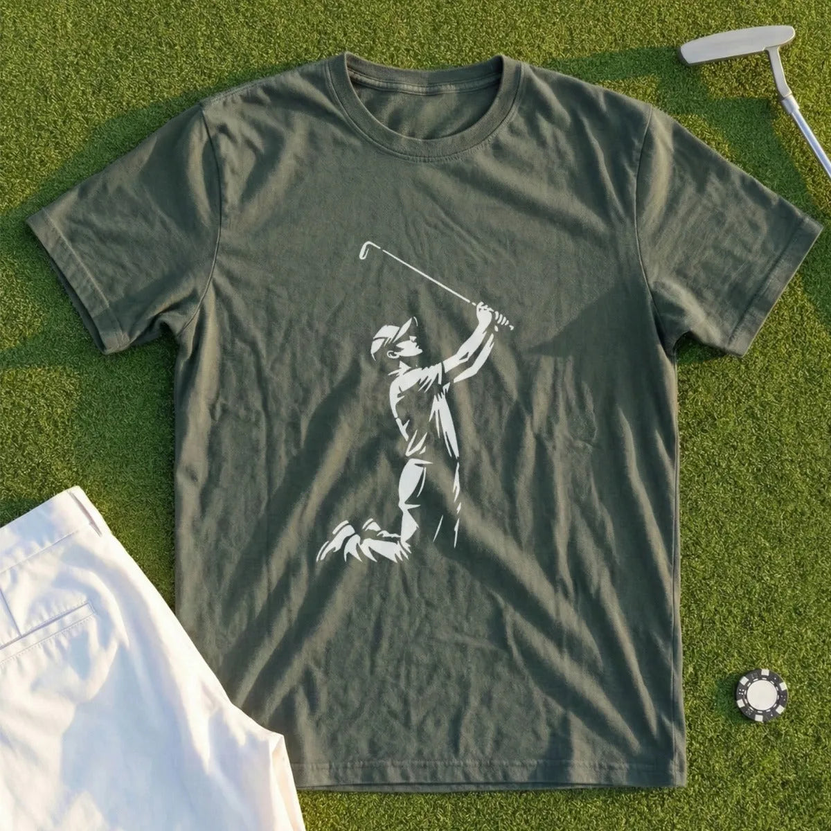 Green t-shirt with golfer silhouette in action, white shorts, and golf ball.