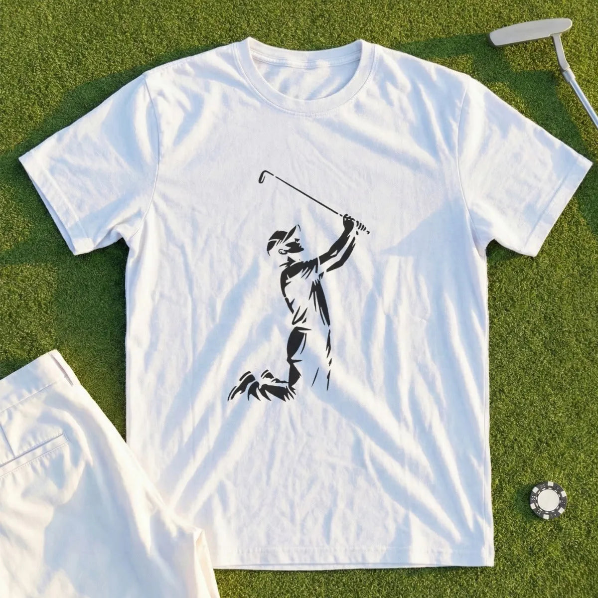 White t-shirt with black silhouette of a golfer swinging, beside white golf shorts.
