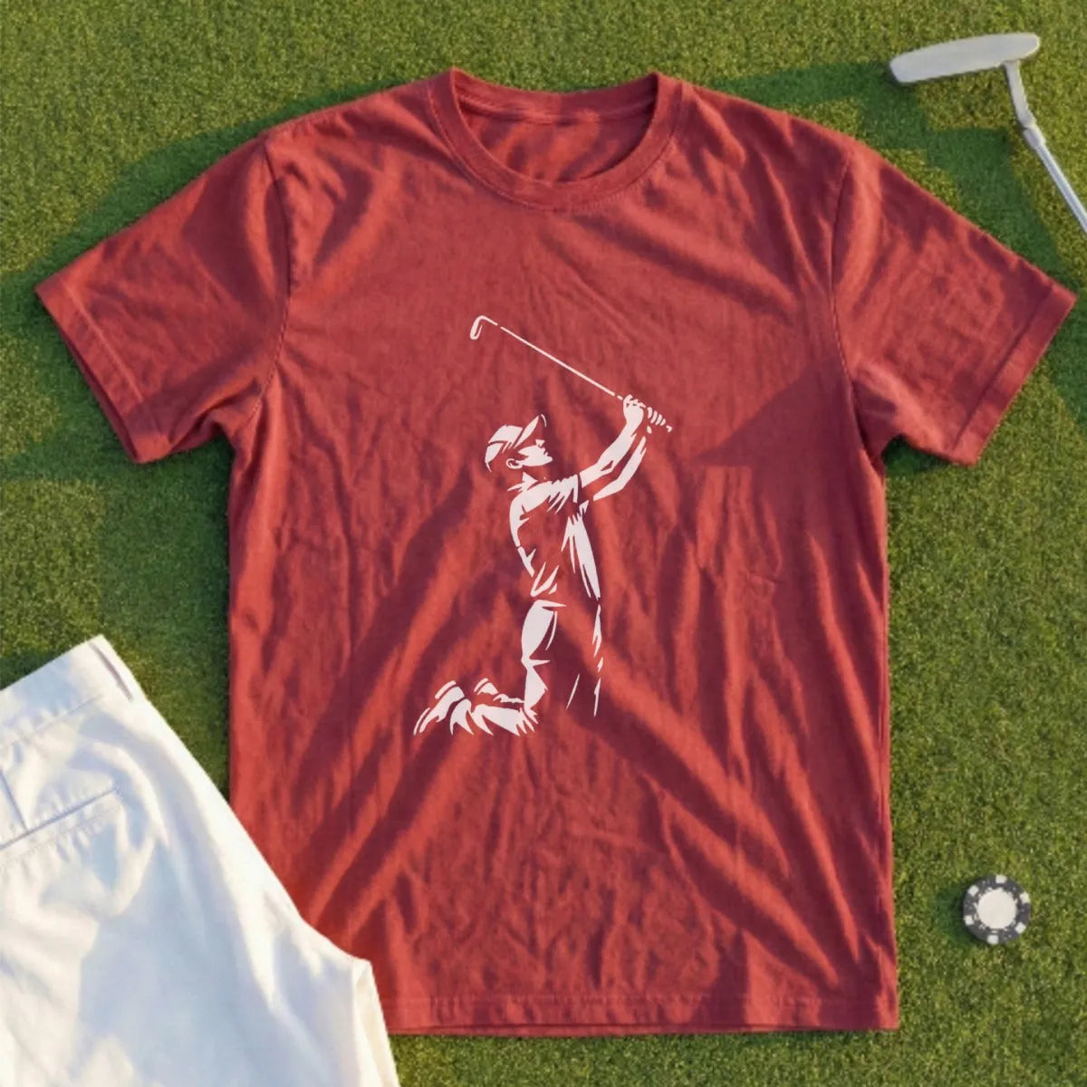 Red t-shirt with golfer graphic, white pants, golf tee, and club.