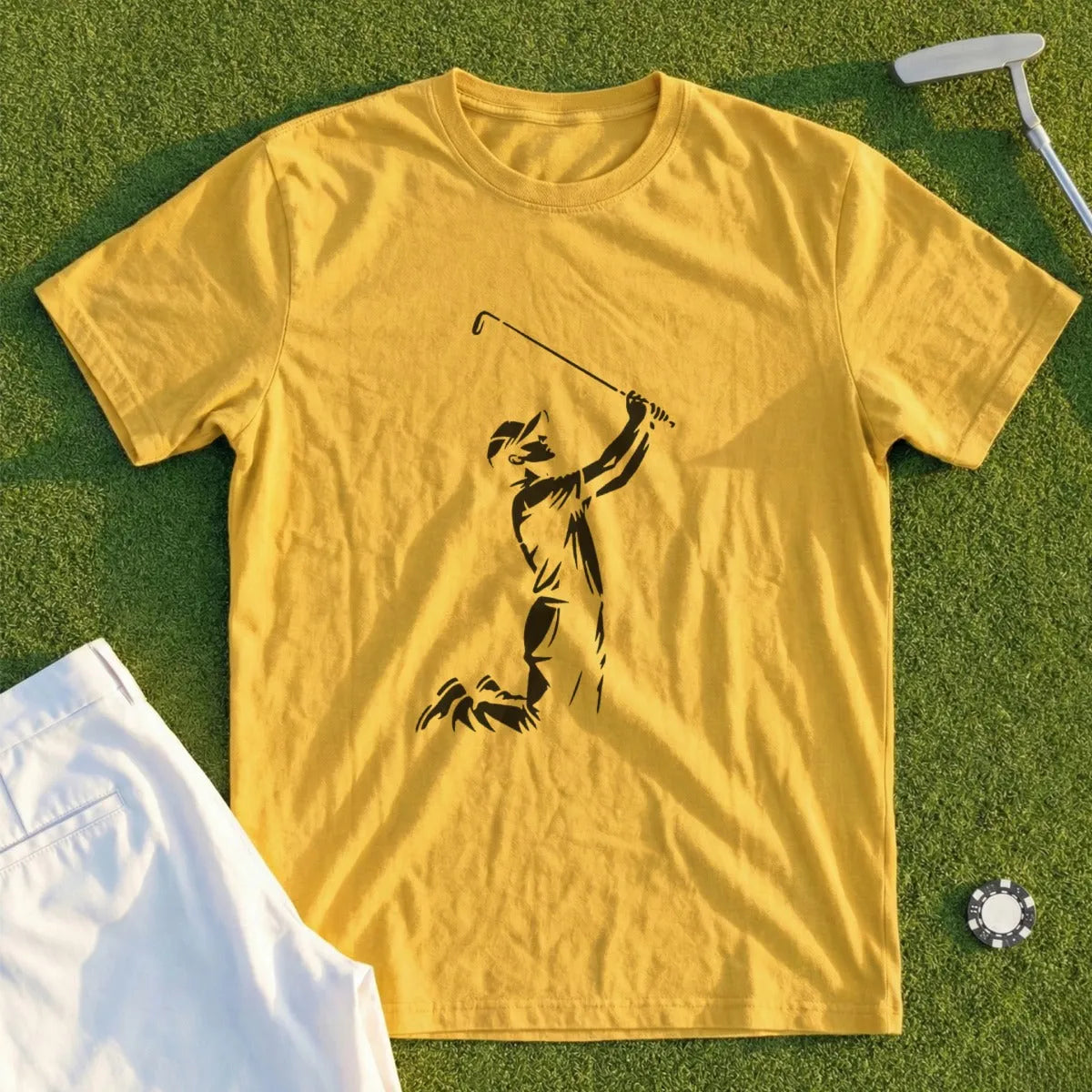 Yellow t-shirt with a golfer silhouette in a swing, white pants, and golf ball marker.