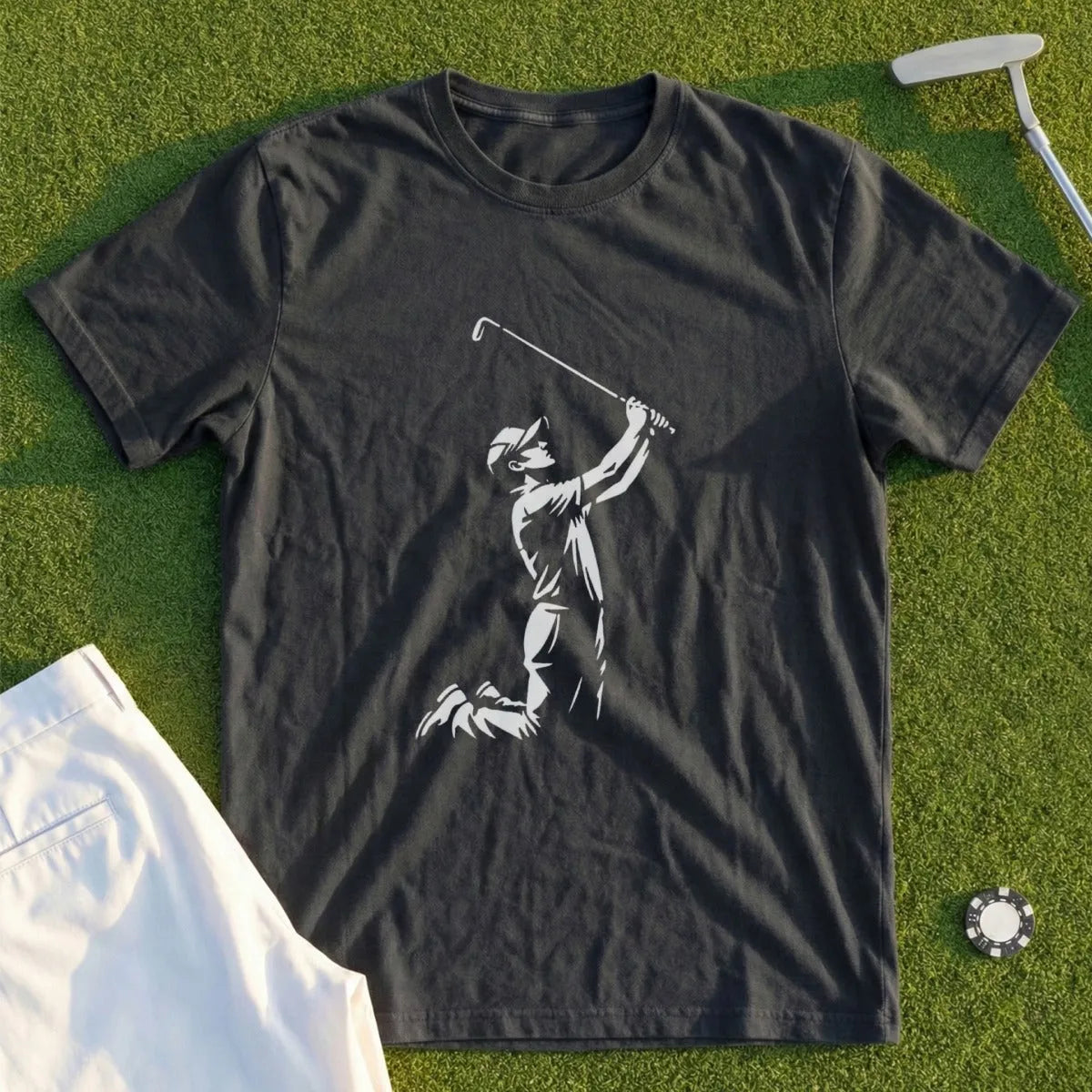 Dark t-shirt with graphic of golfer in mid-swing, white pants, and golf ball.