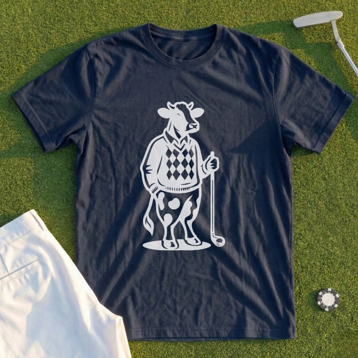 Dark blue t-shirt with a white graphic of a cow wearing a diamond argyle vest and holding a golf club.