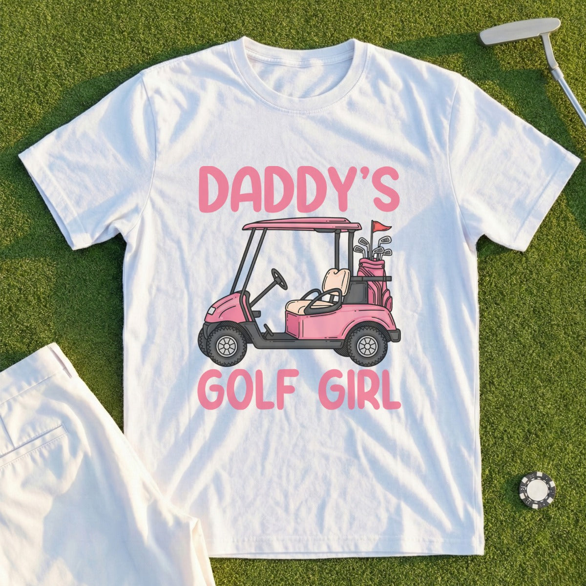 White t-shirt with pink text "DADDY'S GOLF GIRL" and a cartoon golf cart.