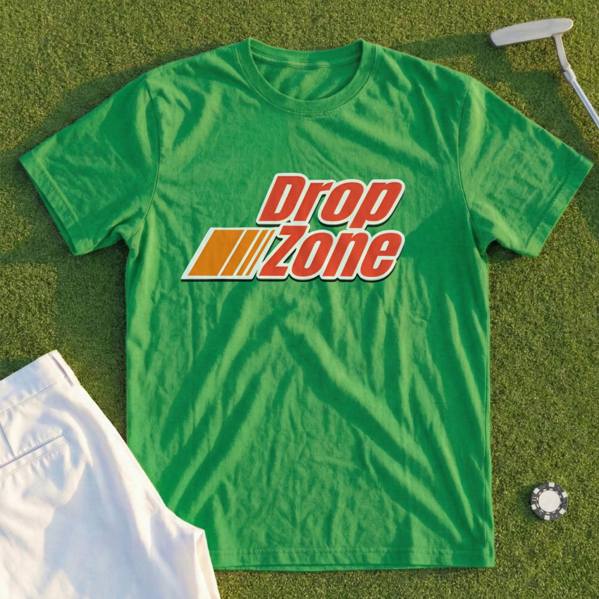 Green t-shirt with orange and white "Drop Zone" text, lying on grass with golf attire.