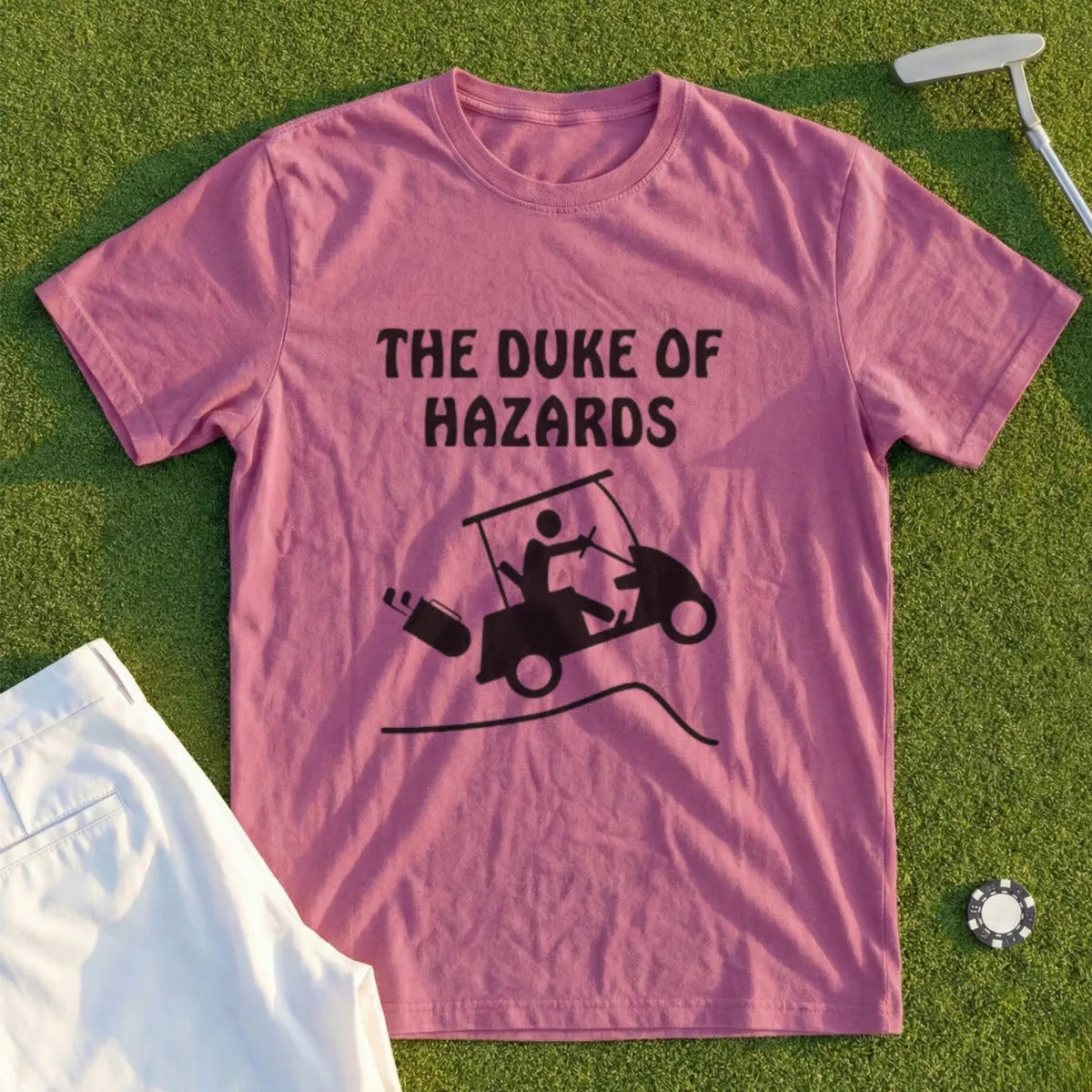 Pink t-shirt with black graphic of a golf cart tipping over and the text "THE DUKE OF HAZARDS".