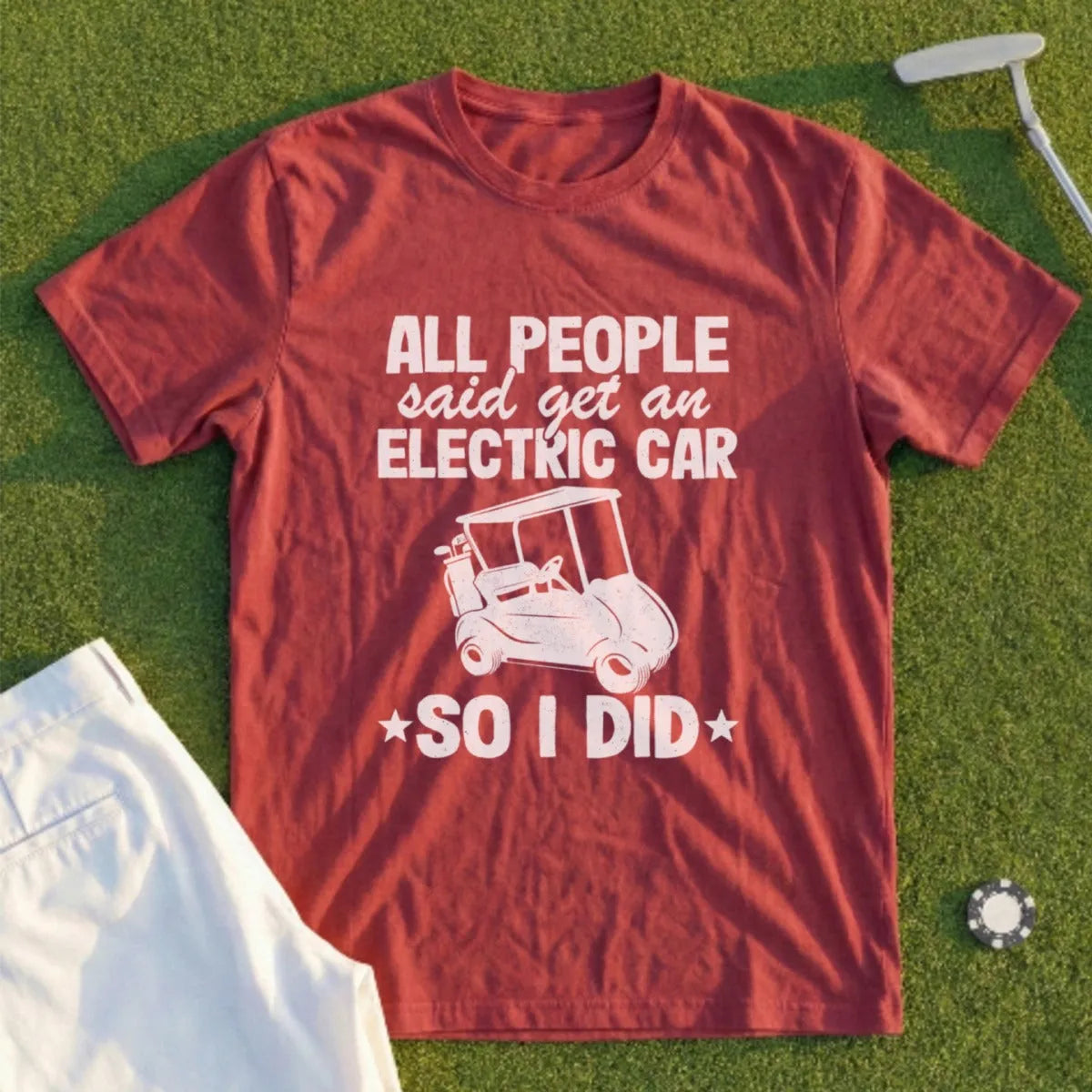 Maroon t-shirt with white text and graphic: "All people said get an electric car, so I did."