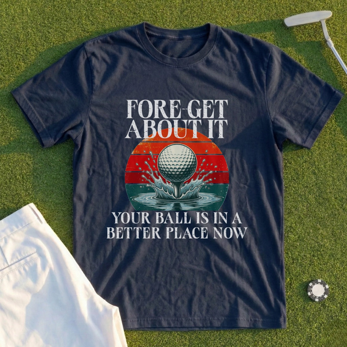 Navy t-shirt with "FORE-GET ABOUT IT YOUR BALL IS IN A BETTER PLACE NOW" and golf ball on tee.