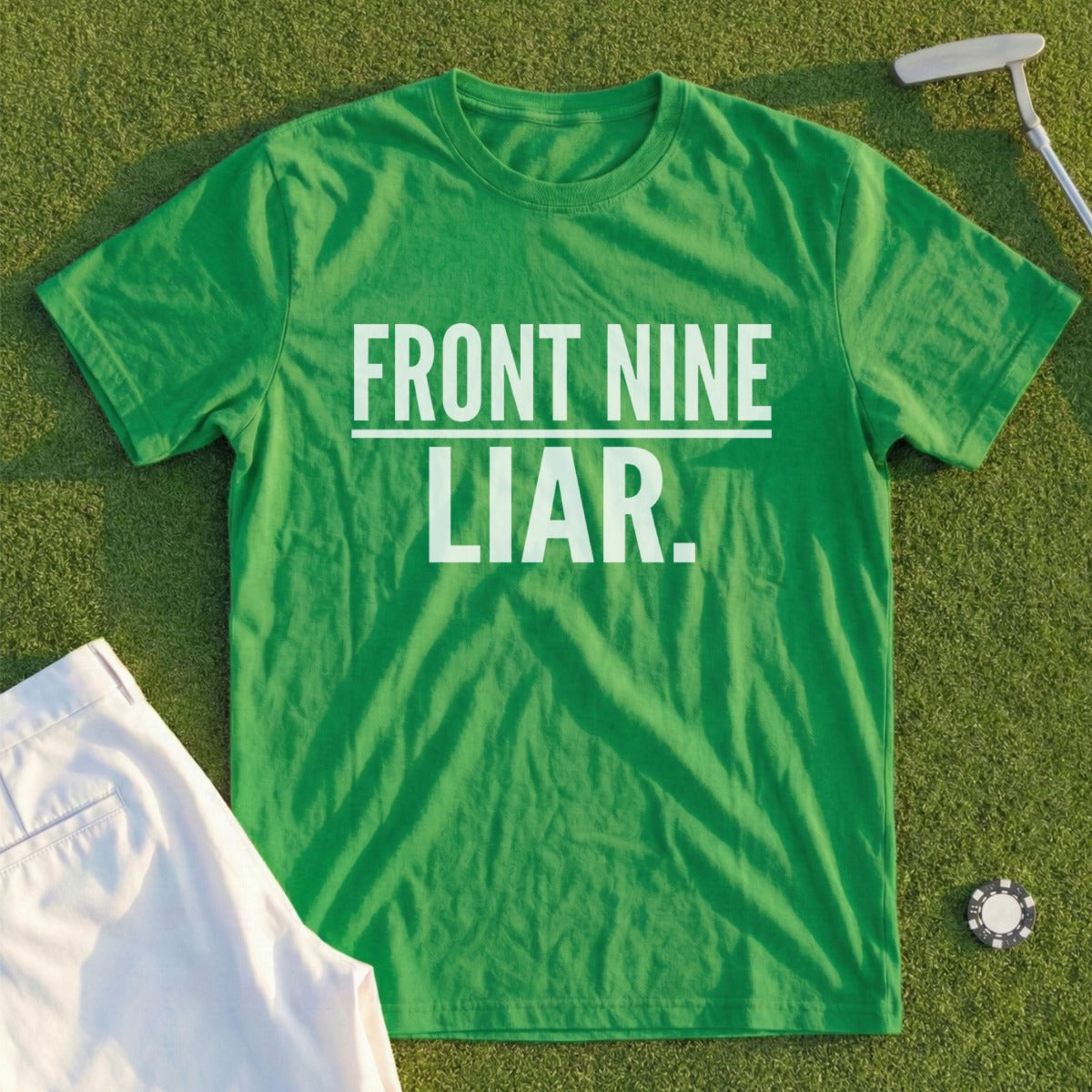 Green t-shirt with "FRONT NINE LIAR." text, golf tee, and white shorts.