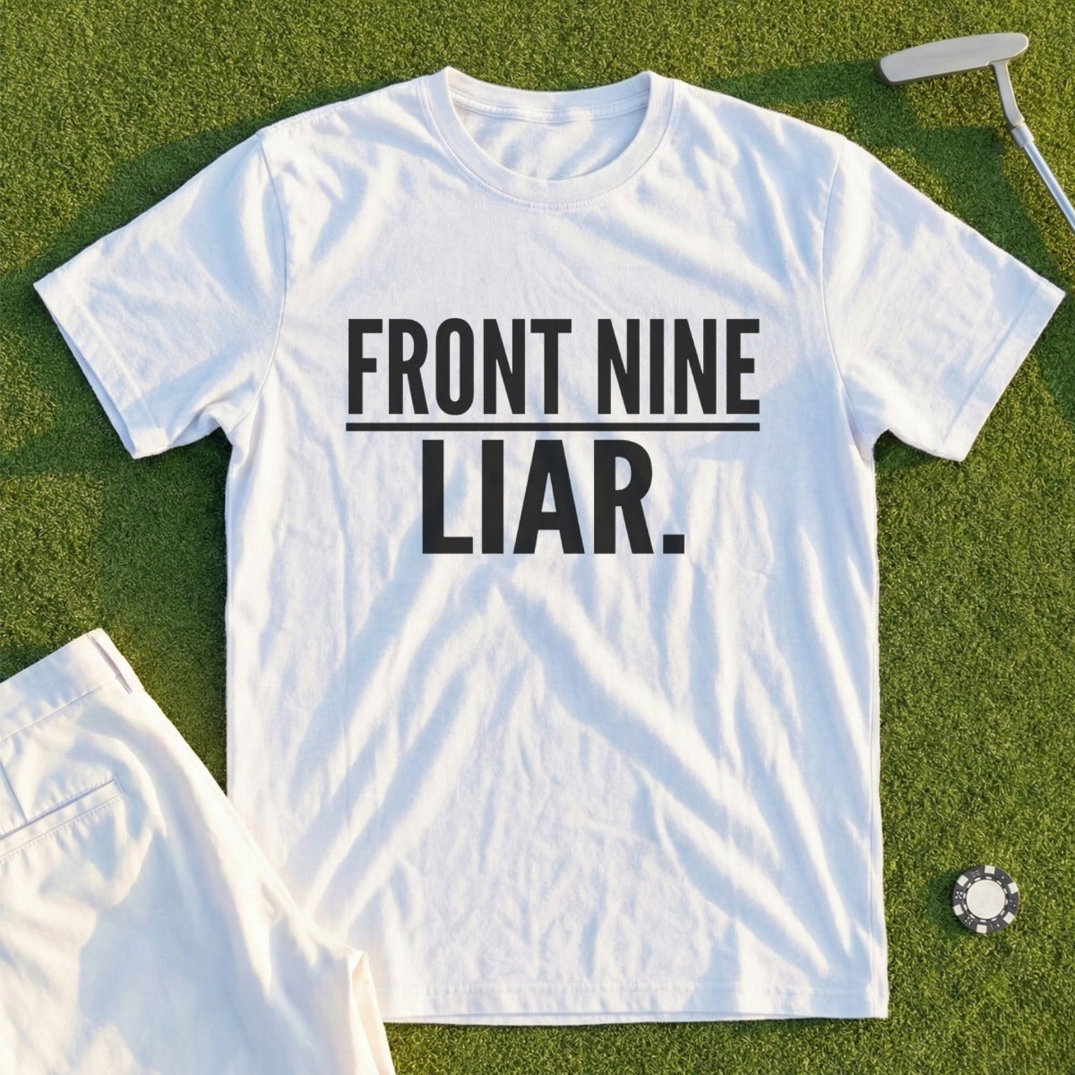 White t-shirt with "FRONT NINE LIAR" text on grass with golf ball and club.