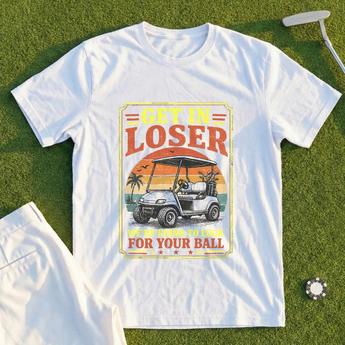 White t-shirt with graphic of a golf cart and text "Get in loser, we're going to look for your ball."