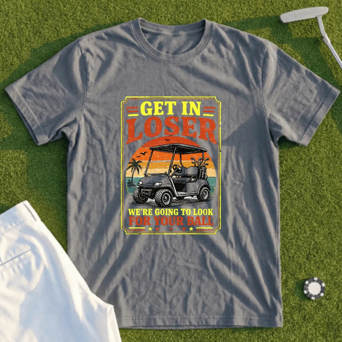 Gray t-shirt with "GET IN LOSER WE'RE GOING TO LOOK FOR YOUR BALL" text and golf cart graphic.