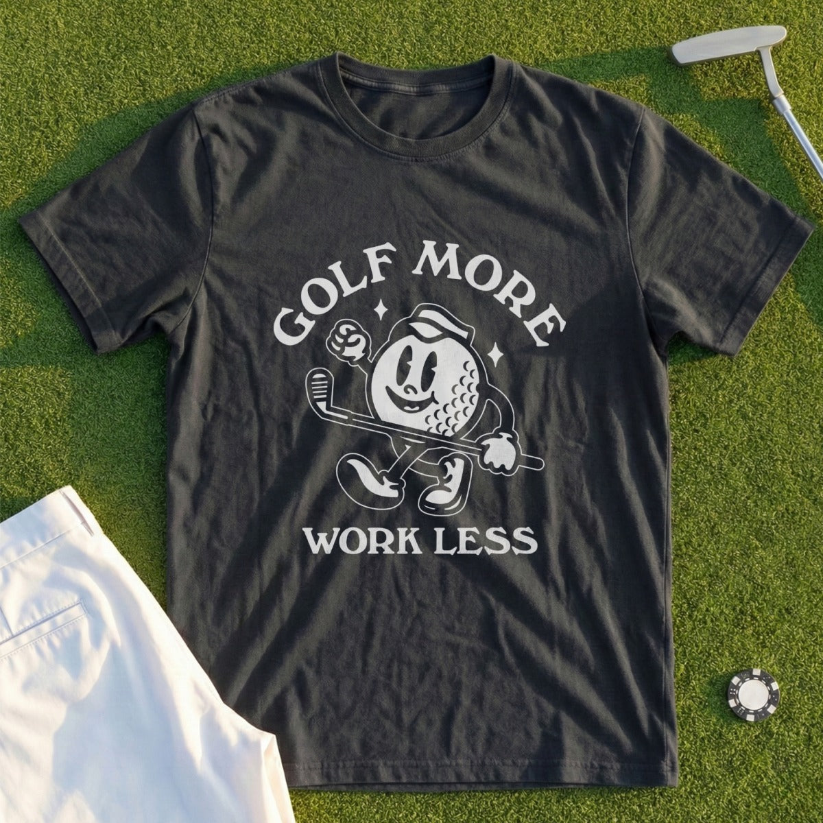 Black t-shirt with cartoon golf ball and text "Golf More Work Less".