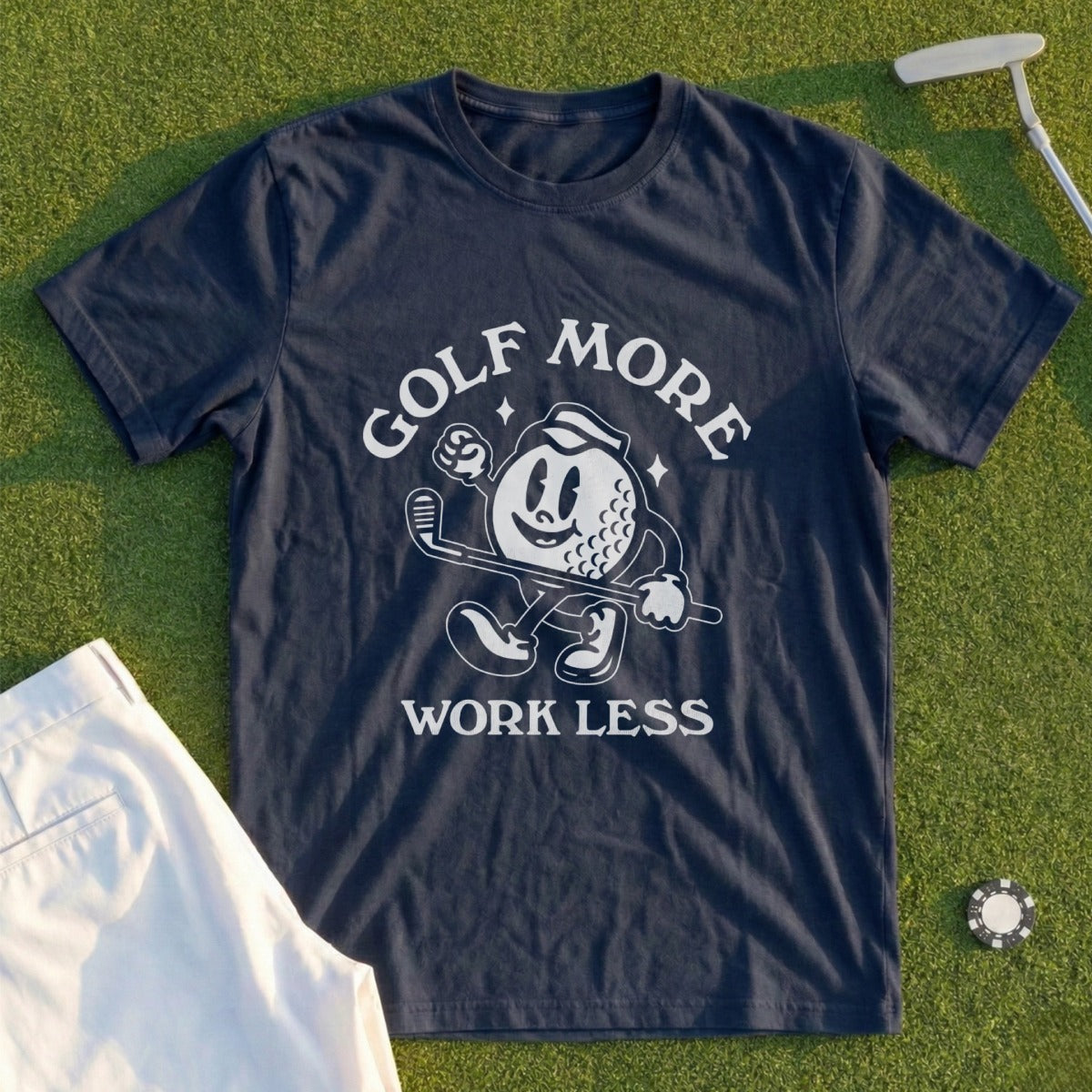 Navy t-shirt with cartoon golf ball character and text "Golf More Work Less".