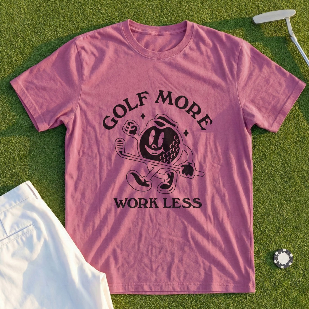 Pink t-shirt with "GOLF MORE WORK LESS" text and cartoon golf ball character.