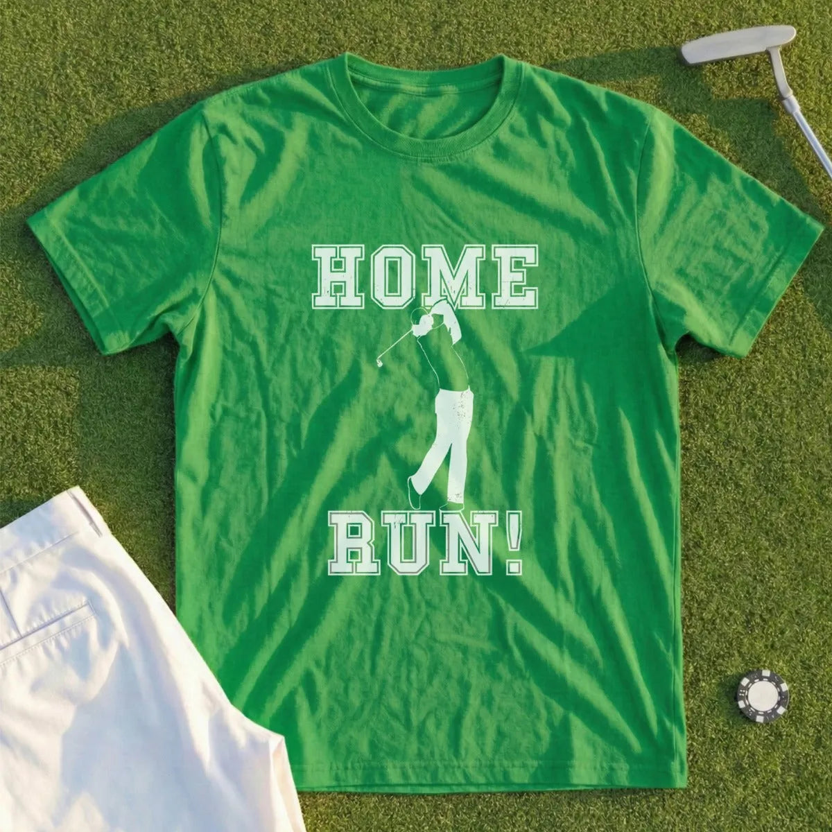 Green t-shirt with white text "HOME RUN!" and golfer graphic on green grass background.