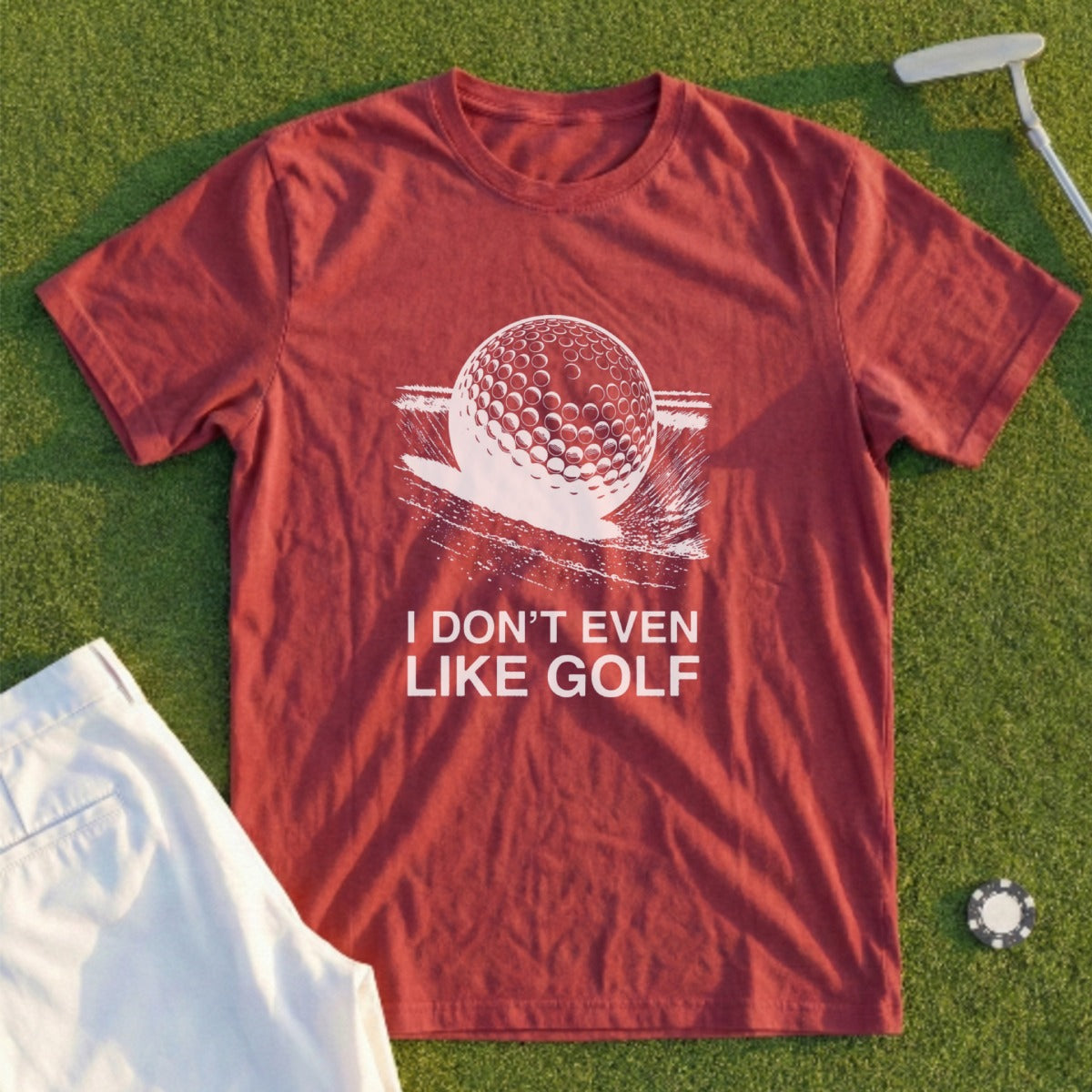 Maroon t-shirt with white graphic of a golf ball and text "I DON'T EVEN LIKE GOLF".