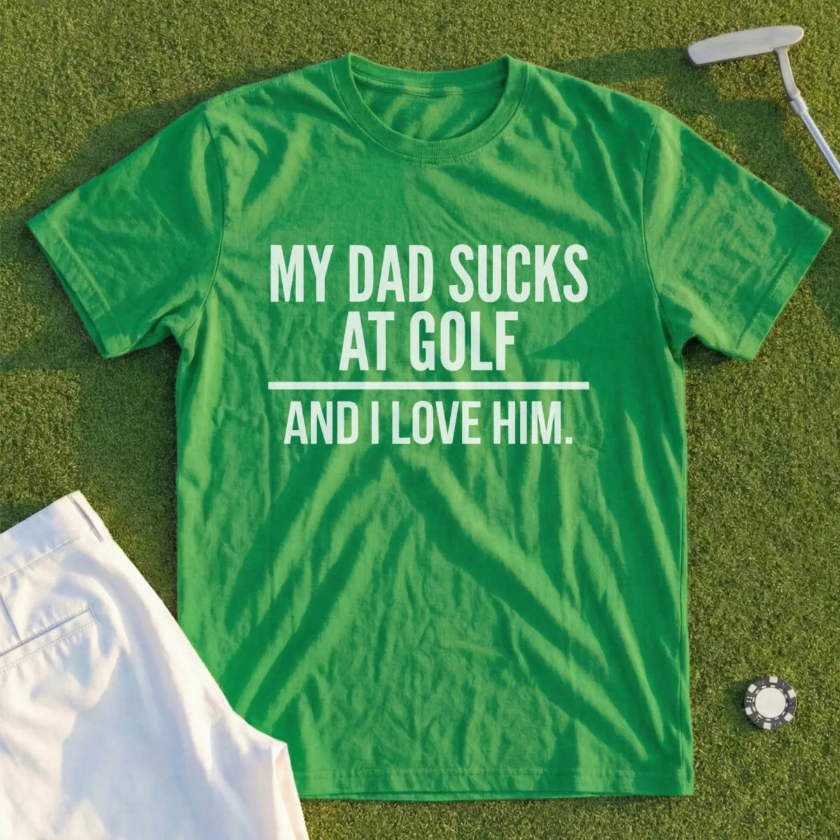 Green t-shirt with white text "MY DAD SUCKS AT GOLF AND I LOVE HIM."