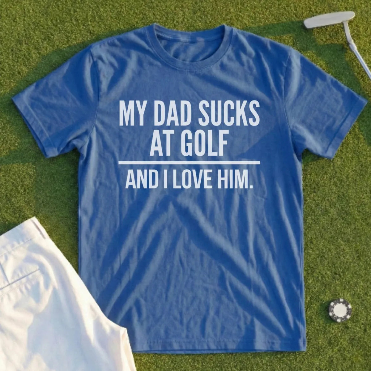 Blue t-shirt with text "MY DAD SUCKS AT GOLF AND I LOVE HIM."