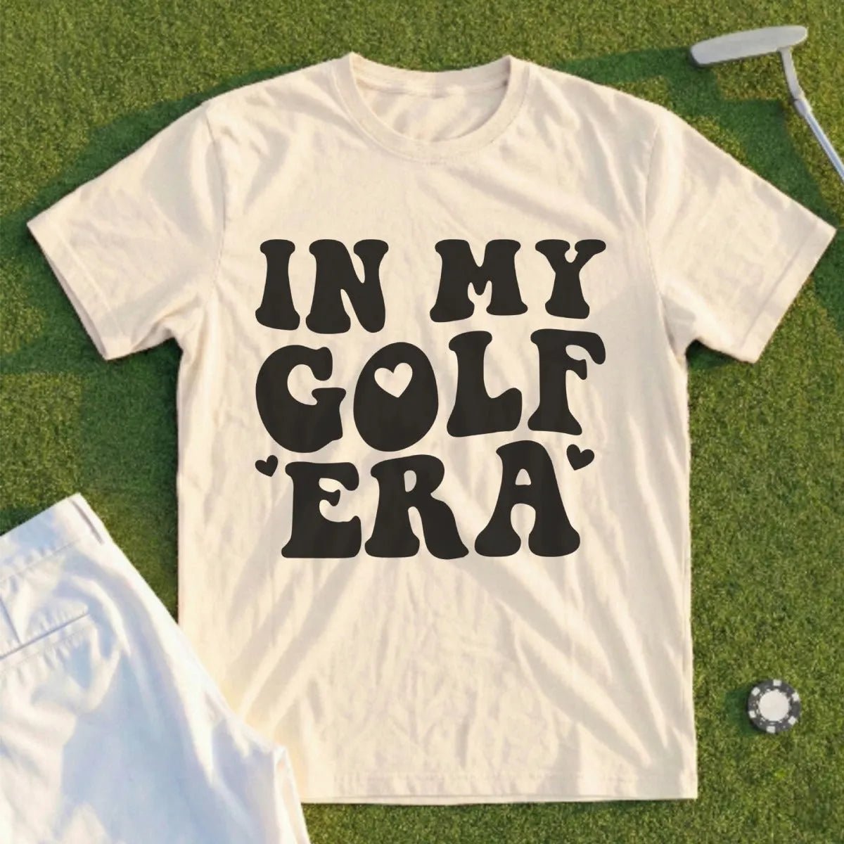 Cream t-shirt with "IN MY GOLF ERA" text and heart graphic.