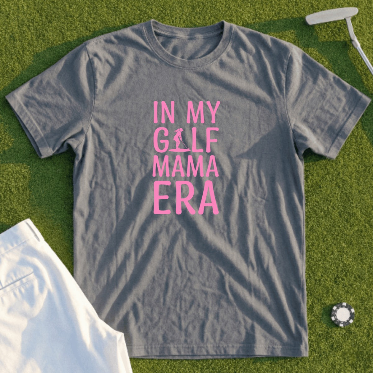 Gray t-shirt with pink text "IN MY GOLF MAMA ERA" on a golf course.