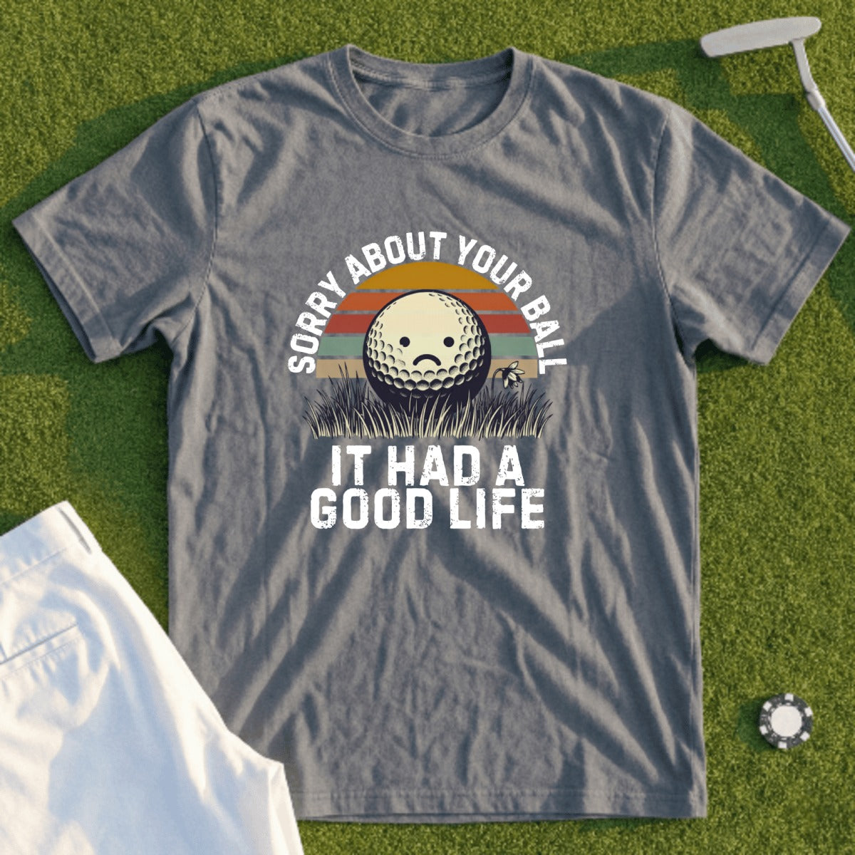 Gray t-shirt with "Sorry About Your Ball, It Had a Good Life" text and sad golf ball graphic.