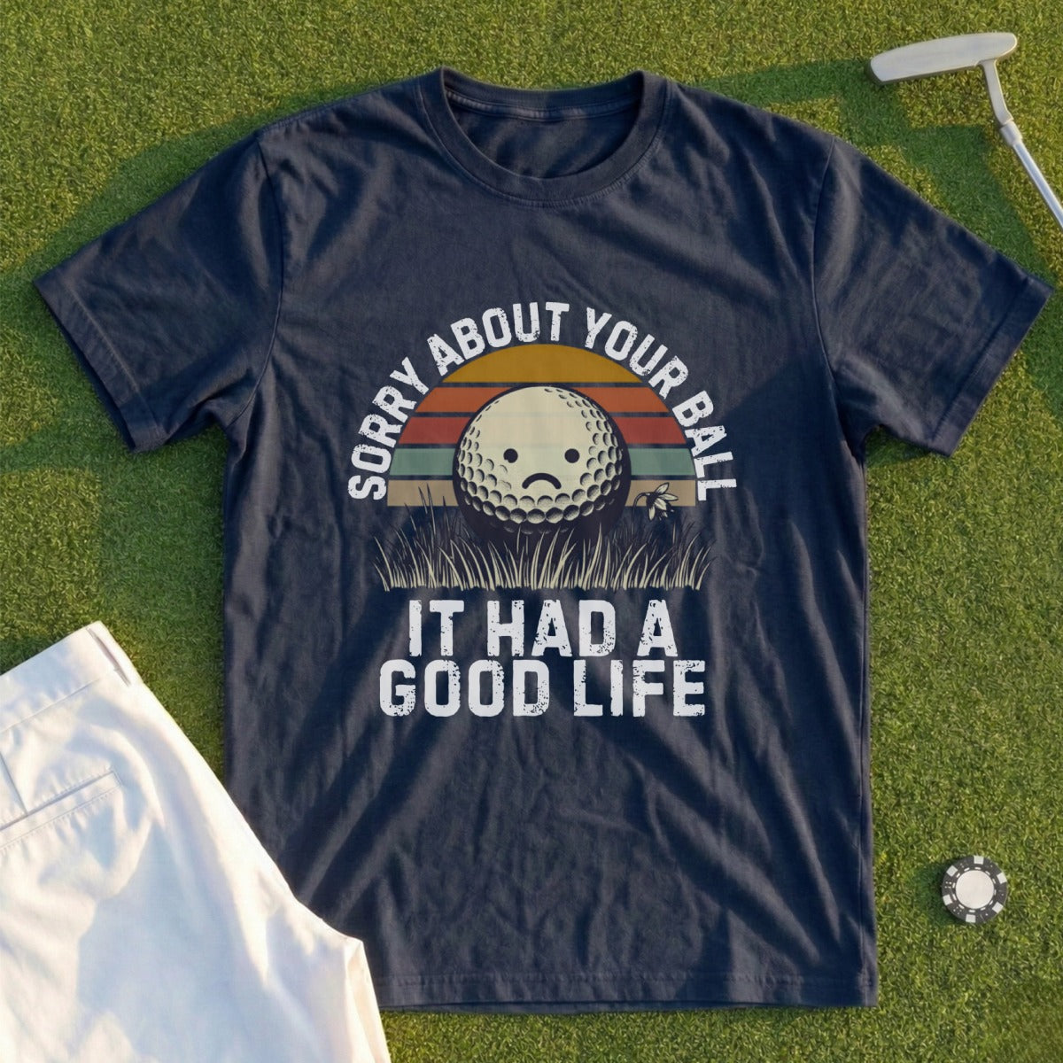Dark blue t-shirt with a distressed golf ball graphic and text "Sorry About Your Ball It Had a Good Life."